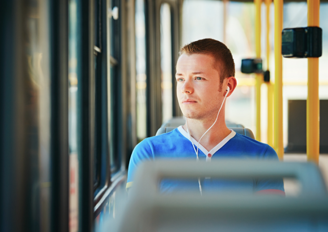 Man in bus kijkt dromerig voor zich uit