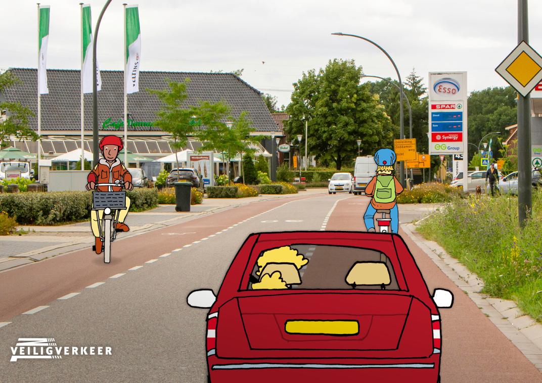 Een rode auto rijdt op een weg waar ook fietsers op de weg fietsen. Auto’s en fietsers moeten rekening met elkaar houden.