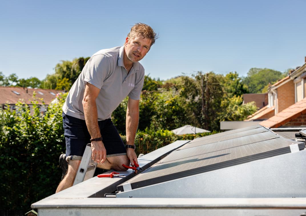 Man die zonnepanelen op het dak legt