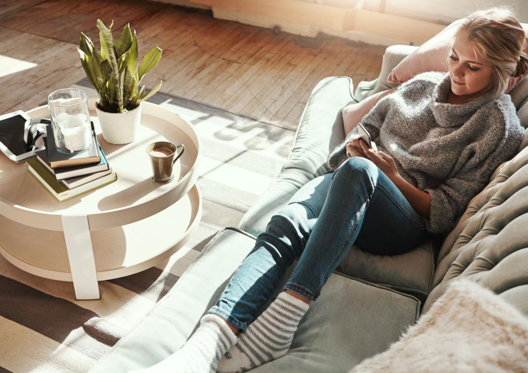 Vrouw ligt op de bank met wollen sokken aan