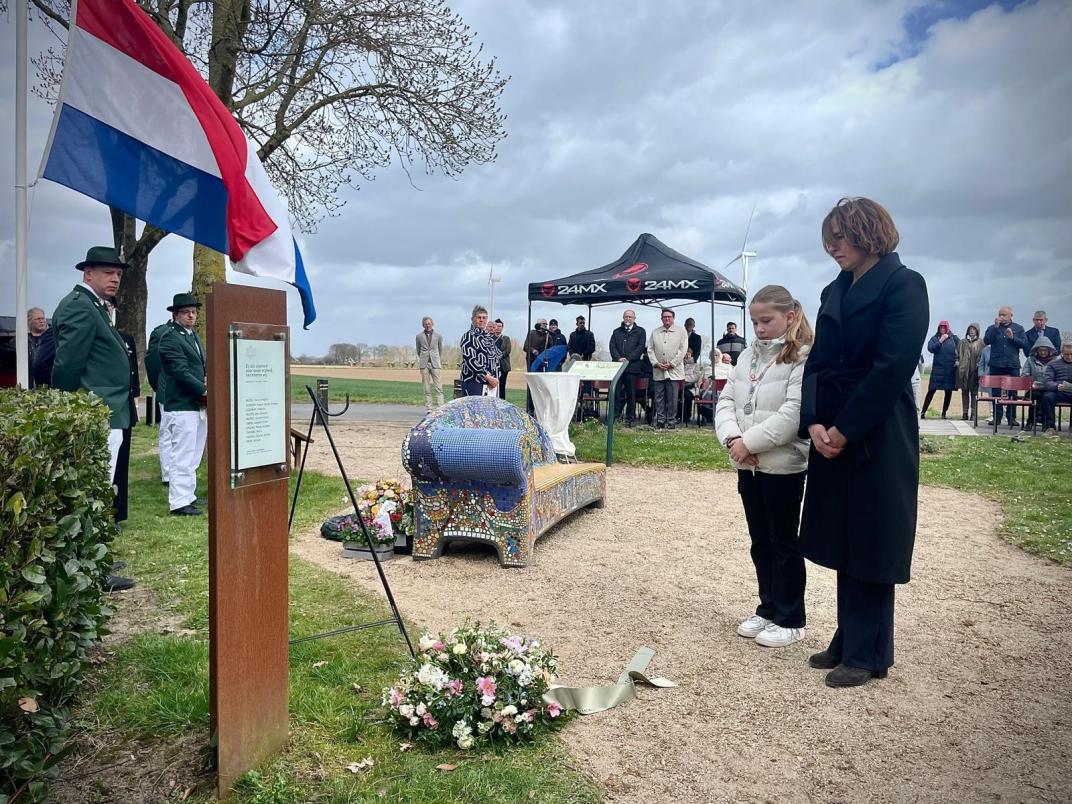 Kinderburgemeester Jill en wnd. burgemeester Mirjam Maasdam leggen bloemen bij het monument n Netterden