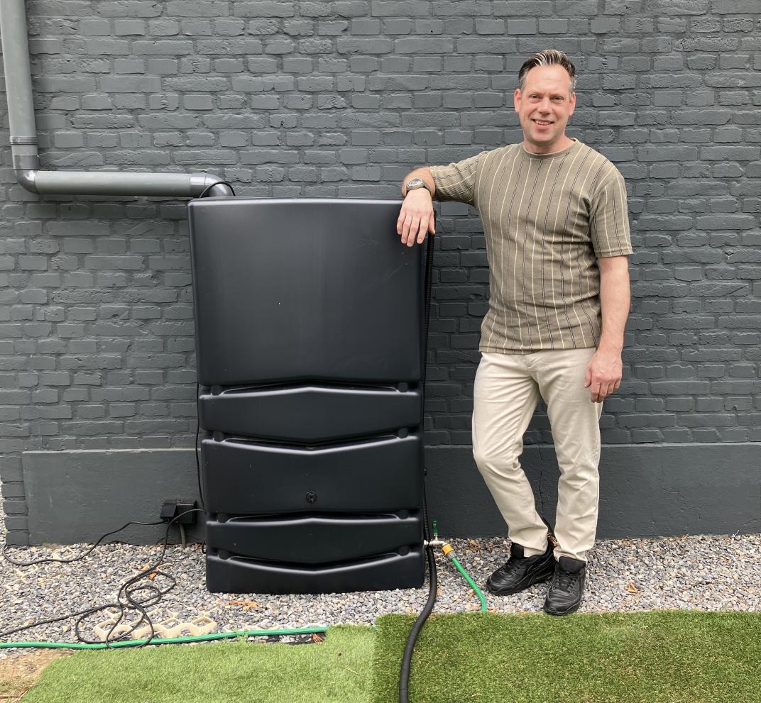 Jeroen bij een van de regentonnen in zijn tuin