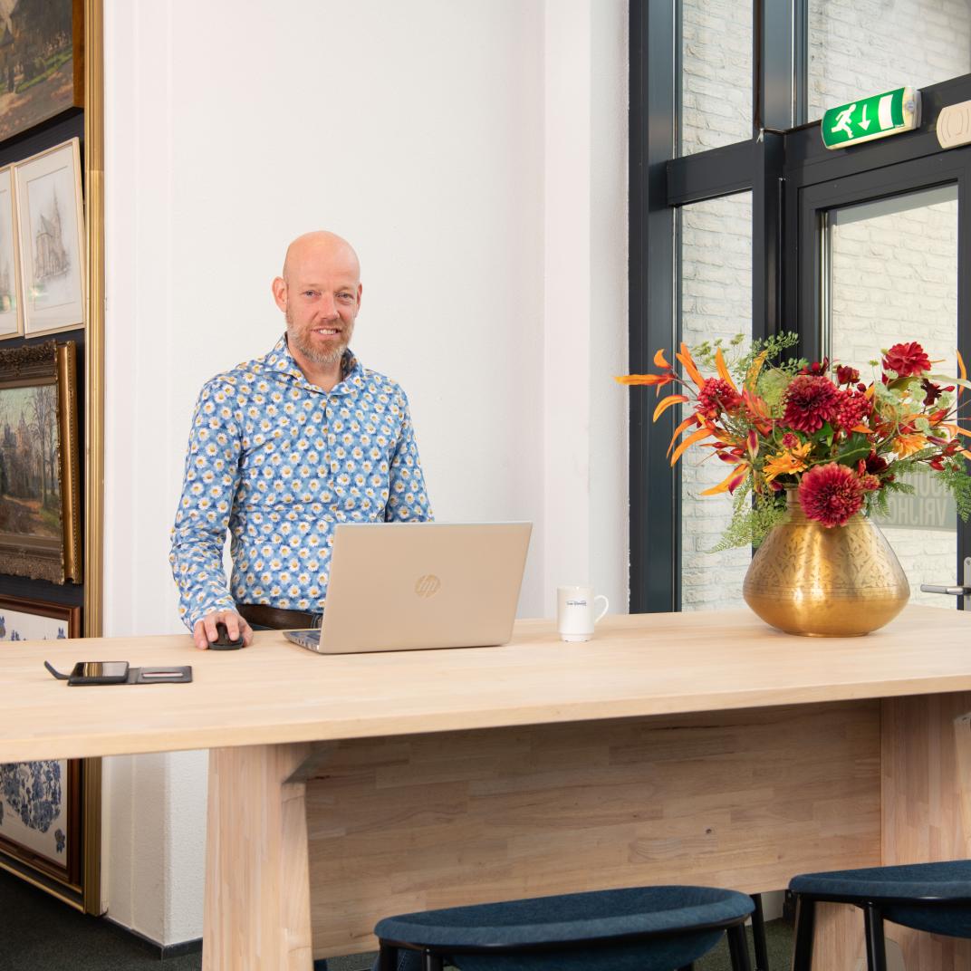 Dienstverlener Informatievoorziening Mark Heister achter zijn laptop in het werkcafé van het gemeentehuis 
