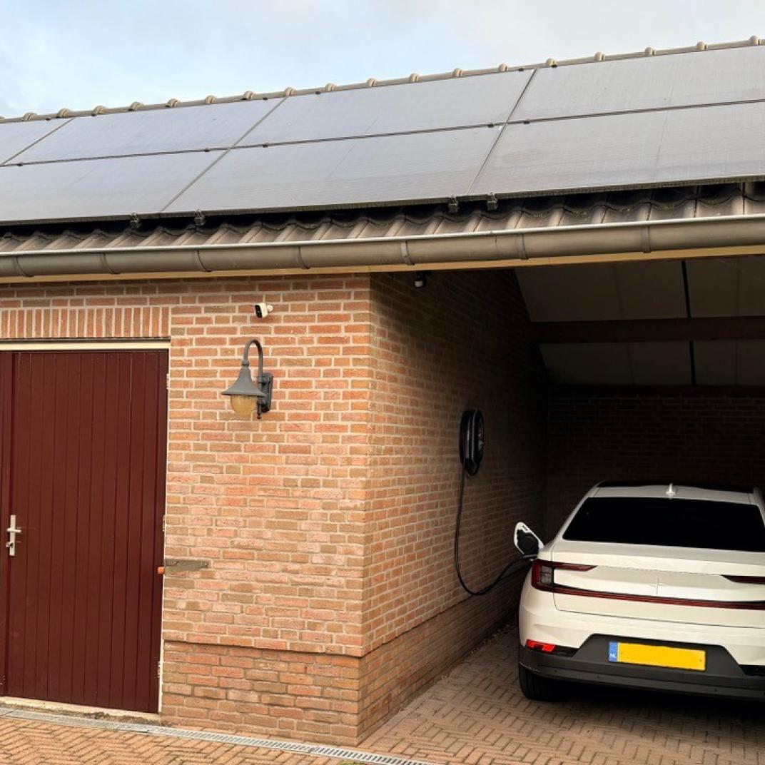 Auto laden aan laadpaal onder carport 